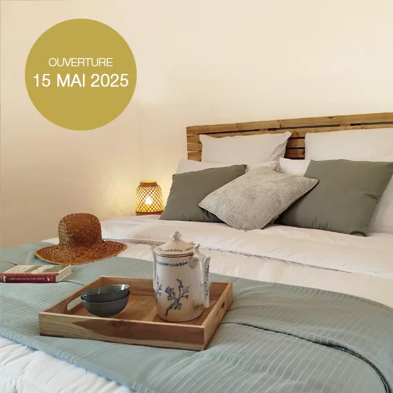 accueil-chambre Lit confortable de la chambre d'hôtes de Terre de Plaisirs, aménagé avec des matériaux naturels.